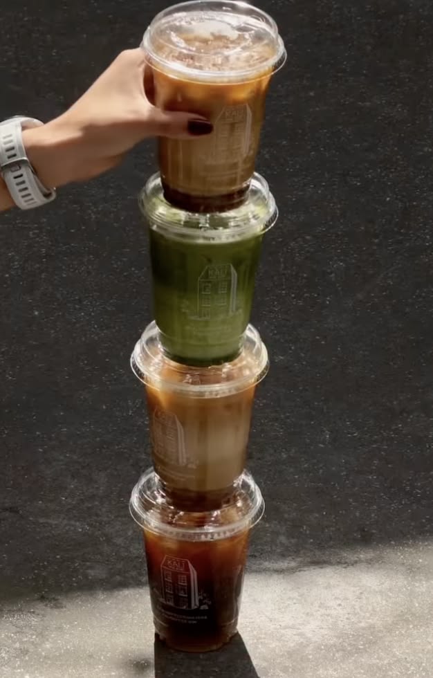 A stack of iced coffees and a matcha
